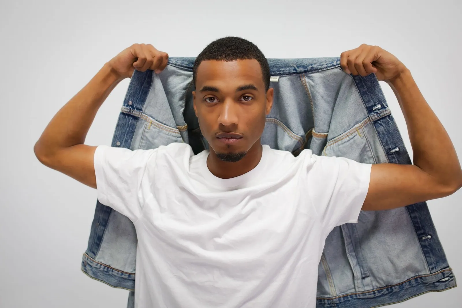 Vonté Smith holding a denim jacket over his shoulders